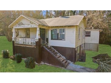 Exterior of home with a covered porch, painted siding, and a yard on a sunny day at 2183 Rhinehill Se Rd, Atlanta, GA 30315
