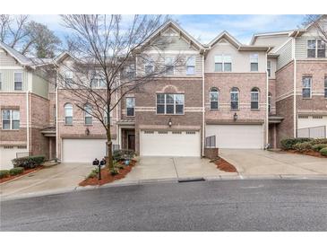 Charming brick townhome featuring an attached two-car garage and well-manicured landscaping at 2363 Palladian Manor Se Way # 4, Atlanta, GA 30339