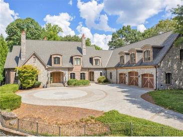 Stunning stone home with a circular driveway and mature landscaping at 2554 Emerald Dr, Jonesboro, GA 30236
