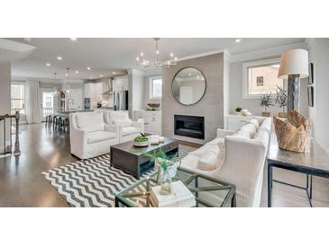 Bright living room featuring a fireplace, modern chandelier, and a stylish chevron rug at 1696 Lansmere Sw St, Marietta, GA 30008
