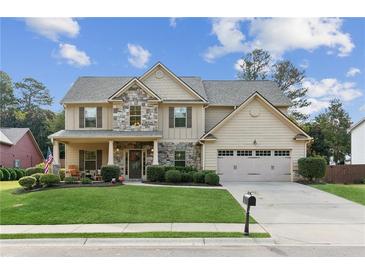Charming two-story home featuring stone accents, manicured lawn, and a welcoming front porch at 3975 Silverthorn Trce, Cumming, GA 30028