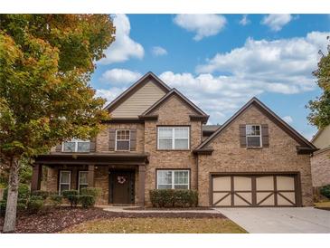 Charming two-story brick home with manicured landscaping and a welcoming front porch at 5825 Trailwood Ct, Suwanee, GA 30024