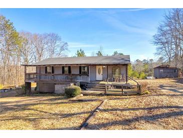 Charming ranch home featuring a spacious porch and classic architectural details on a sunny day at 1315 Woodland Sw Dr, Oxford, GA 30054