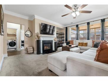 Inviting living room featuring a fireplace, plush seating, and natural light at 590 Palm Springs Cir, Fairburn, GA 30213