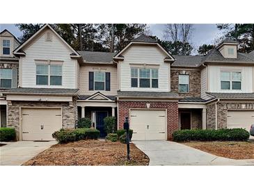 Charming townhome with brick and siding exterior, attached garages, and manicured landscaping at 5107 Madeline Pl, Stone Mountain, GA 30083