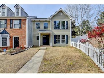 Charming two-story home with a well-manicured lawn and inviting front porch and attractive architectural details at 1284 Warsaw Rd, Roswell, GA 30076