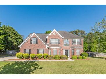 Charming two-story brick home with manicured lawn and mature landscaping at 104 Sunflower Meadows Dr, Mcdonough, GA 30252