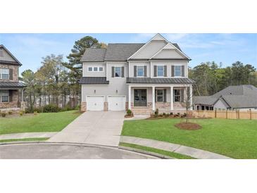 Charming two-story home with a well-manicured lawn, a two-car garage and a welcoming front porch at 5424 Gallagher Ct, Powder Springs, GA 30127