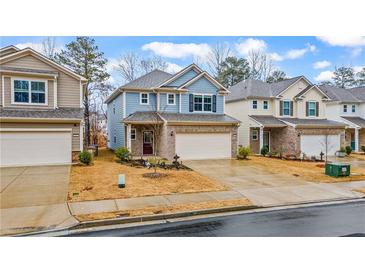 Charming two-story home featuring a brick facade, attached two-car garage, and a well-manicured front yard at 5915 Pinnacle View Rd, Cumming, GA 30040
