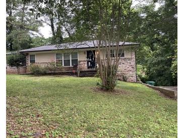 Charming single-story home with a brick facade, lush green lawn, and mature trees in a serene, residential neighborhood at 2380 Fair Ln, Decatur, GA 30032