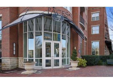 Beautiful brick building entrance featuring double glass doors and elegant landscaping at 325 E Paces Ferry Ne Rd # 2005, Atlanta, GA 30305