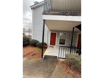 Two story gray home with a red front door, well-maintained landscaping, and a covered entryway at 4351 Timberlake, Stone Mountain, GA 30083