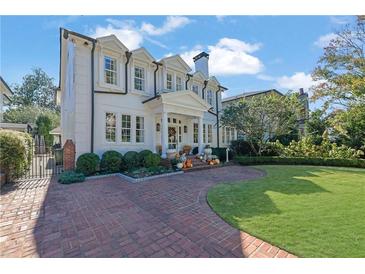 Elegant two-story home with a brick driveway, manicured landscaping, and charming front porch at 115 17Th Ne St, Atlanta, GA 30309