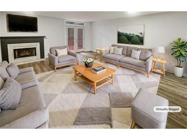 Bright, staged living room with a fireplace, modern furniture, and access to an outdoor area at 6420 Wedgeview Dr, Tucker, GA 30084