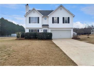 Charming two-story home with a manicured lawn, two car garage and dark shutters at 166 Floresta Dr, Mcdonough, GA 30252