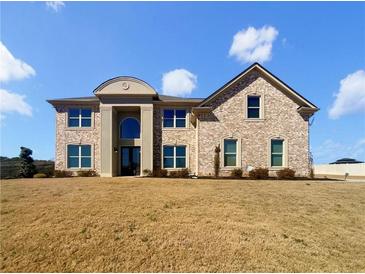 Stately two-story brick home with arched entryway and manicured front lawn at 3308 Steeple Chase Sw Way, Conyers, GA 30094