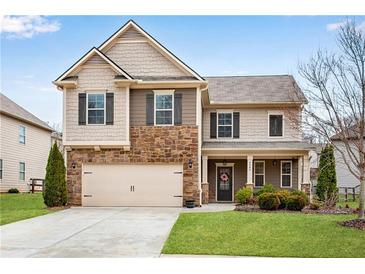 Charming two-story home with stone accents, a well-manicured lawn, and a two-car garage at 4080 Huron Dr, Cumming, GA 30028