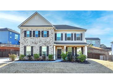 Charming two-story home featuring a brick facade, well-manicured lawn, and inviting front porch at 4825 Odum View Ln, Cumming, GA 30040