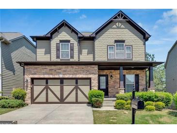Charming two-story home featuring stone accents, a two-car garage, and a beautifully landscaped front yard at 5928 Cobblestone Creek Cir, Mableton, GA 30126