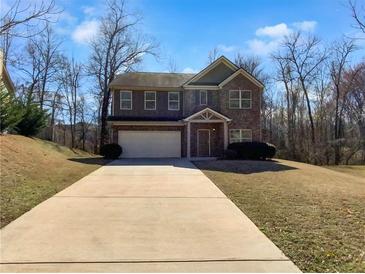 Charming two-story home with brick facade and a spacious front yard and extended driveway at 1181 Paramount Dr, Mcdonough, GA 30253