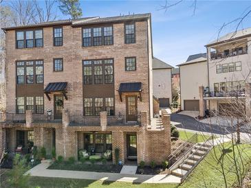 Brick townhome featuring private patios, dark window trim, and a well-manicured lawn at 6838 Prelude Dr, Atlanta, GA 30328