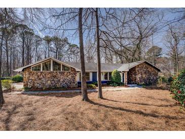 Charming stone-accented home with a modern architectural design and mature trees in the front yard at 825 Sugar Creek Se Way, Conyers, GA 30094