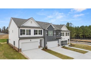 Beautiful townhomes featuring modern architecture, two-car garages, and manicured lawns at 6322 Rosetta Dr # 1, South Fulton, GA 30331