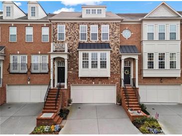 Charming townhome featuring a brick facade, attached garage, and inviting curb appeal with manicured landscaping at 2782 Loftview Sq, Atlanta, GA 30339