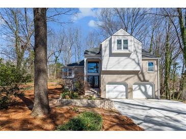 Charming two-story home with a brick-and-siding exterior and a well-manicured front yard and attached two car garage at 1521 Bentcreek Dr, Marietta, GA 30062