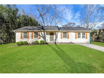 Charming renovated single-story home featuring a well-manicured front yard with a newly paved driveway at 3096 Highland Se Dr, Smyrna, GA 30080