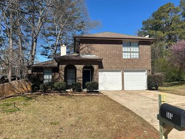 Charming brick two-story home with well-maintained lawn, landscaping, and two-car garage at 503 N Shore Rd, Lithonia, GA 30058