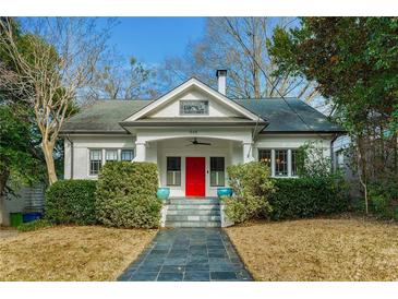 Charming white bungalow with a red front door and manicured landscaping at 648 Cooledge Ave, Atlanta, GA 30306