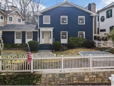 Charming blue two-story home with white picket fence and landscaped front yard at 124 The Prado, Atlanta, GA 30309