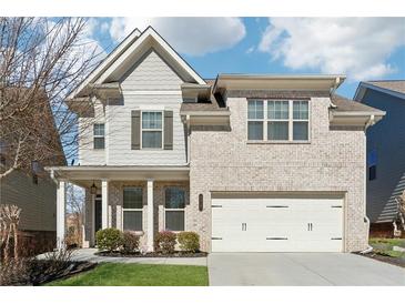 Charming two-story home features a well-manicured lawn, two-car garage, and a welcoming covered porch at 4727 Tiger Blvd, Duluth, GA 30096