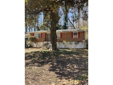 Charming single-story brick home with mature tree and walkway leading to the front door at 982 Scott Cir, Decatur, GA 30033