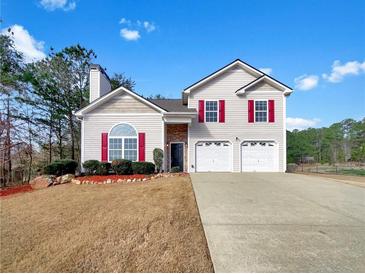 Charming two-story home featuring red shutters, a two car garage, and well-maintained landscaping at 242 Meadow Spring Dr, Temple, GA 30179