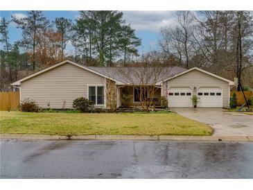 Charming single-story home with a well-manicured lawn and a two-car garage at 106 Lanyard Bnd, Peachtree City, GA 30269