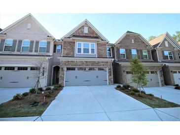 Charming brick townhome featuring attached garages and well-manicured front lawns at 680 Mason Grove Pkwy, Lawrenceville, GA 30043