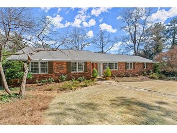 Charming brick home with meticulously maintained lawn and mature trees, offering classic curb appeal at 541 Hickory Sw Dr, Marietta, GA 30064