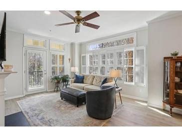 Bright living room featuring a ceiling fan, large windows, and access to a balcony at 424 Lindbergh Ne Dr # 201, Atlanta, GA 30305