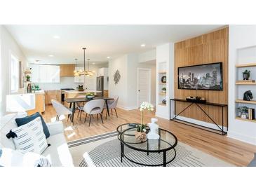 Open-concept living room with modern decor, hardwood floors, and seamless flow to kitchen and dining areas at 1667 Grace Se St, Atlanta, GA 30316