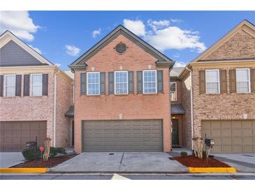 Charming brick townhome featuring a two-car garage and well-maintained landscaping at 1921 Harrison Park Dr, Atlanta, GA 30341