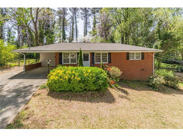 Charming brick home with a well-manicured front yard and inviting carport at 244 Hurt Se Dr, Smyrna, GA 30082