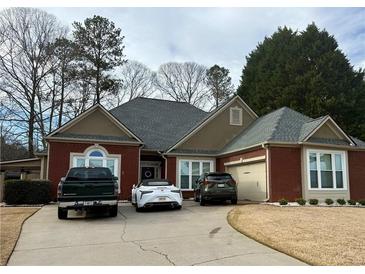 Charming one-story brick home featuring manicured landscaping, a gray roof, and a two-car garage at 60 Saddle Tree Way, Sugar Hill, GA 30518