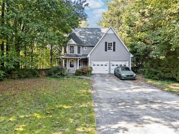 Charming two-story home with mature trees, two-car garage and a long driveway at 395 Lake Swan Ct, Hiram, GA 30141