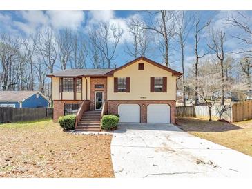 Charming split-level home with a two-car garage, brick accents, and landscaped front yard at 5508 Hadrian Ct, Lithonia, GA 30058