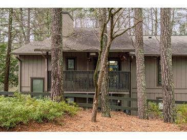 Inviting exterior view of home with a covered porch, complemented by mature trees and lush landscaping at 1901 Cumberland Ct, Smyrna, GA 30080