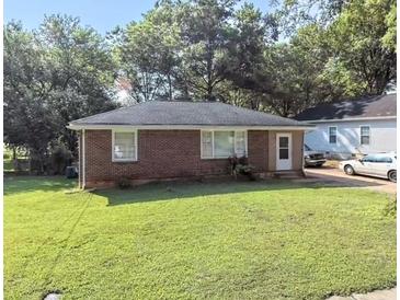 Charming brick home with a well-maintained lawn and mature trees in a quiet neighborhood at 212 Austin Ne Ave, Marietta, GA 30060