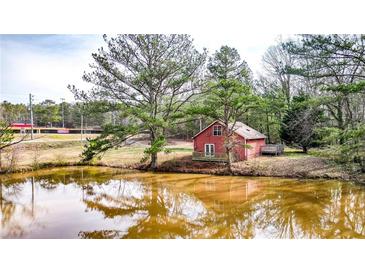 Charming red home with a pond, offering a serene and picturesque setting at 257 Crossroads Church Rd, Rockmart, GA 30153