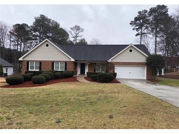 Charming brick home featuring manicured landscaping and a well-maintained front yard at 215 Buck Run, Loganville, GA 30052
